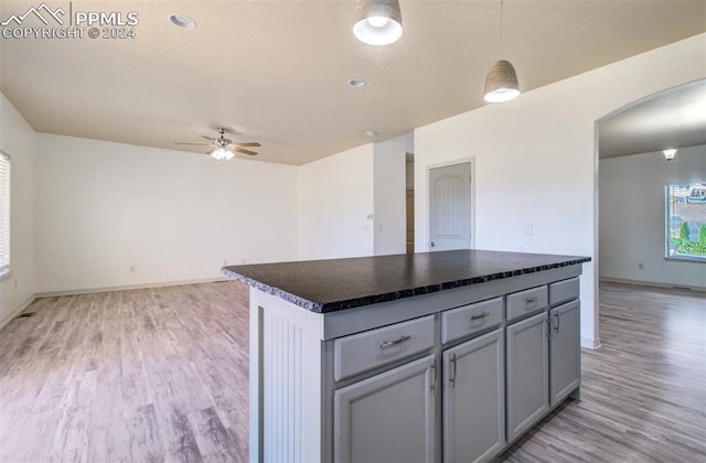 kitchen featuring gray cabinetry, ceiling fan, light hardwood / wood-style flooring, a center island, and hanging light fixtures