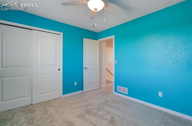 unfurnished bedroom with a closet, ceiling fan, and light colored carpet