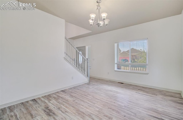 unfurnished living room featuring light hardwood / wood-style flooring and an inviting chandelier