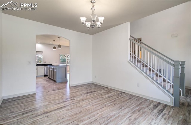 interior space with a notable chandelier and light hardwood / wood-style flooring