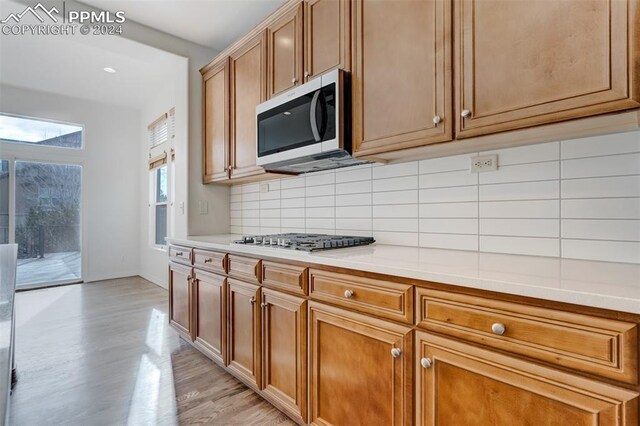 kitchen featuring tasteful backsplash, stainless steel appliances, and light hardwood / wood-style floors