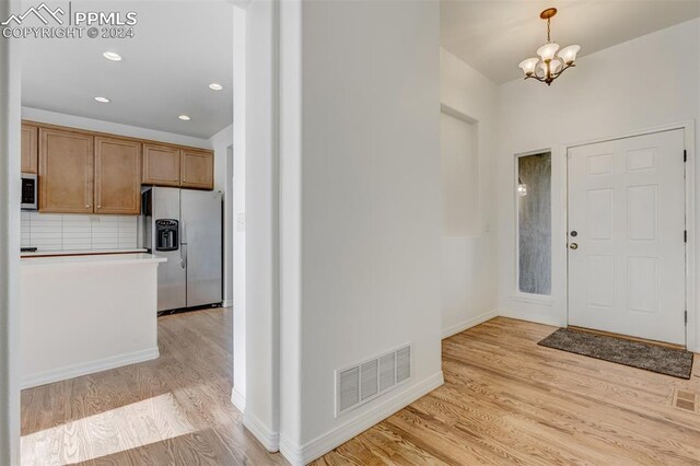 foyer featuring light hardwood / wood-style flooring and a notable chandelier