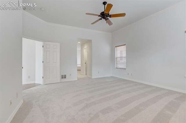 interior space with ceiling fan, ornamental molding, and light carpet