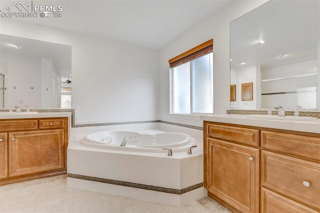 bathroom with vanity, tiled bath, and tile patterned floors