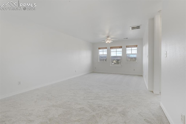 carpeted spare room with ceiling fan