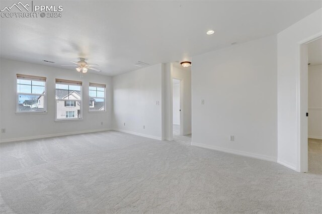 unfurnished room featuring light carpet and ceiling fan