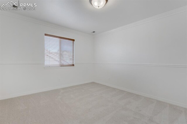 carpeted empty room featuring ornamental molding