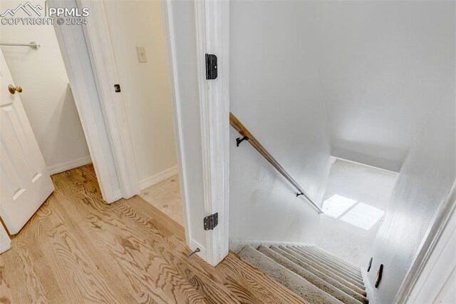 stairway with hardwood / wood-style floors