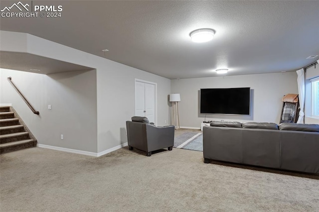 carpeted living room featuring a textured ceiling