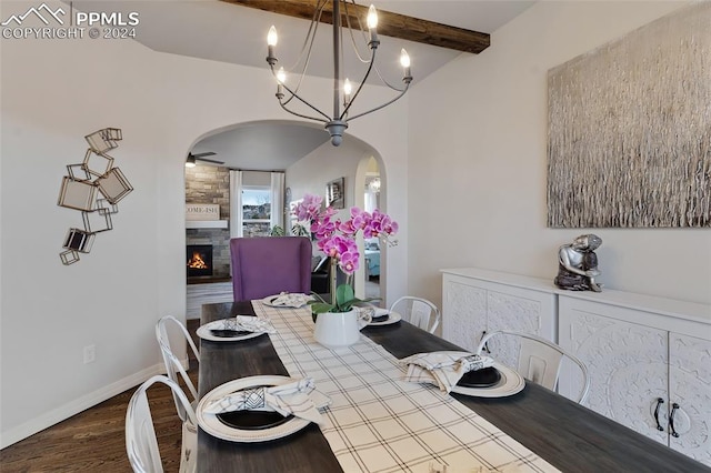 dining space featuring a chandelier, lofted ceiling with beams, a large fireplace, and hardwood / wood-style flooring