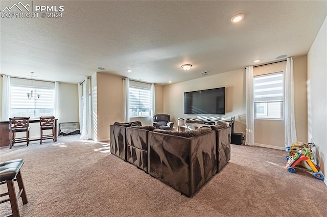 living room featuring light colored carpet, a textured ceiling, and an inviting chandelier