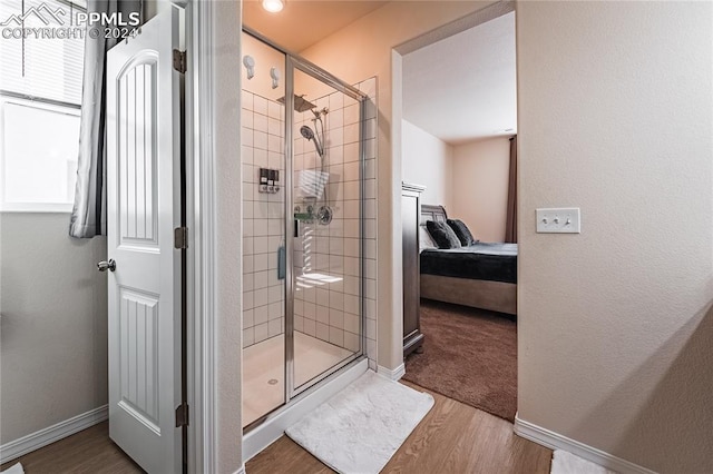 bathroom featuring wood-type flooring and a shower with shower door