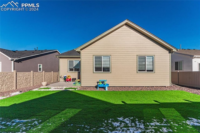 rear view of house featuring a patio and a lawn