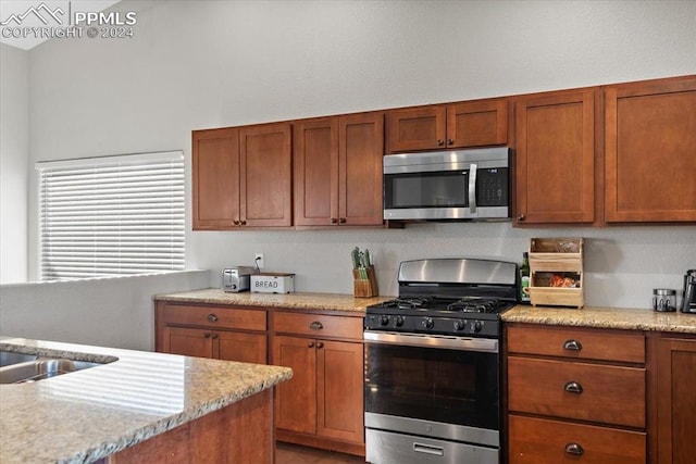 kitchen featuring light stone counters and stainless steel appliances