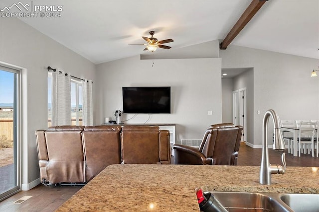 kitchen with ceiling fan, sink, light stone counters, lofted ceiling with beams, and dark hardwood / wood-style floors