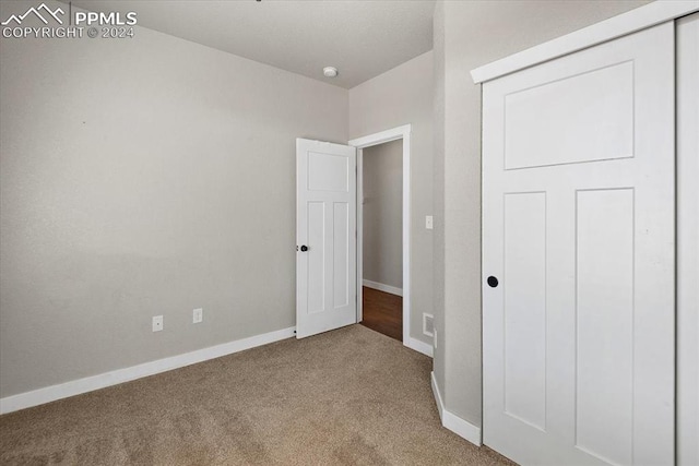 unfurnished bedroom featuring a closet and carpet floors