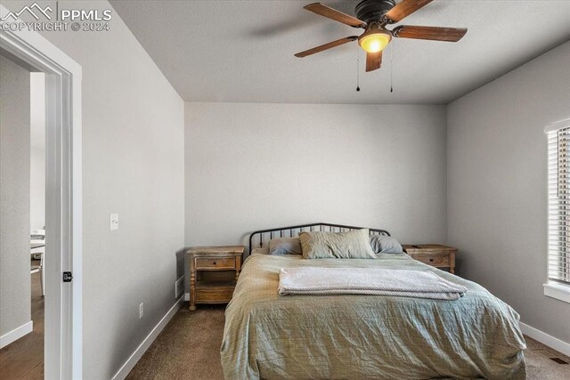 bedroom with dark colored carpet, ceiling fan, and multiple windows