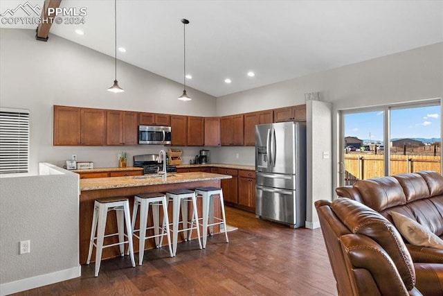 kitchen featuring light stone counters, dark hardwood / wood-style floors, decorative light fixtures, a breakfast bar area, and appliances with stainless steel finishes