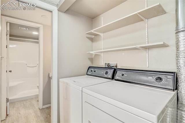 laundry area featuring washer and dryer and light wood-type flooring