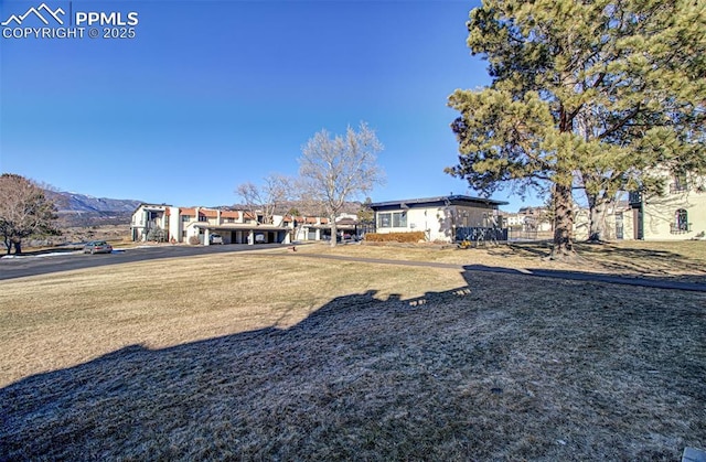 exterior space featuring a front lawn and a mountain view