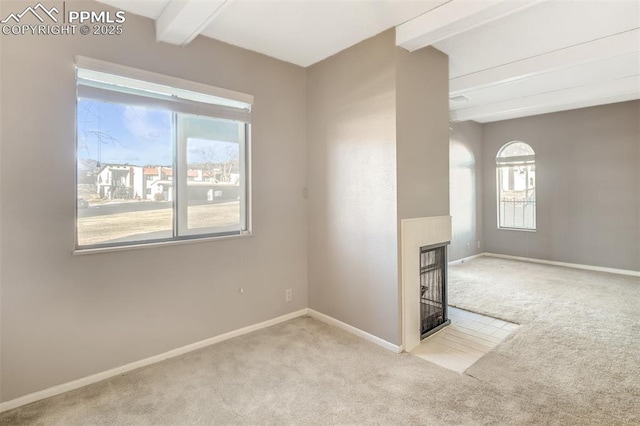 carpeted spare room with beam ceiling and a multi sided fireplace