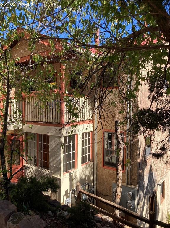 back of property featuring a balcony and stucco siding