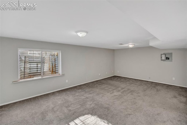 spare room featuring electric panel, carpet, and lofted ceiling