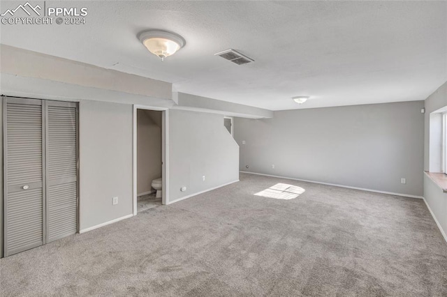 unfurnished bedroom featuring carpet floors and ensuite bath