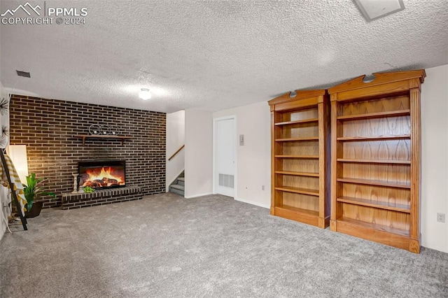 unfurnished living room featuring carpet, a textured ceiling, and a brick fireplace