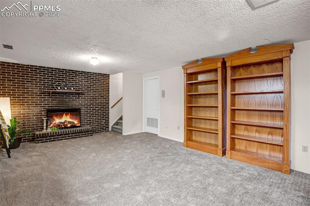 unfurnished living room featuring a fireplace, carpet floors, and a textured ceiling