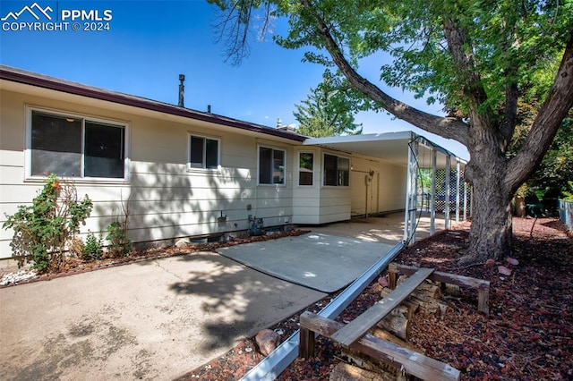 rear view of house featuring a patio and a carport