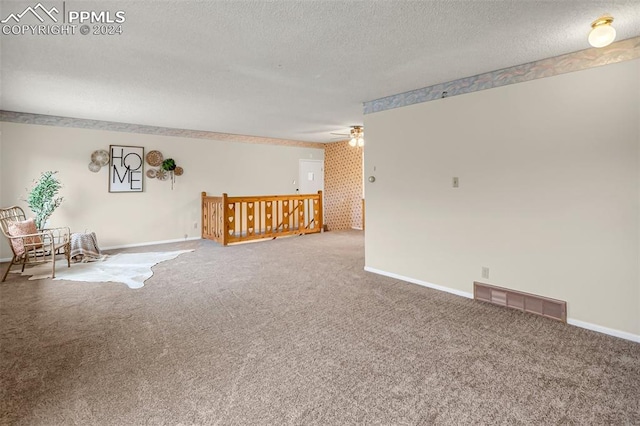 carpeted spare room with ceiling fan and a textured ceiling