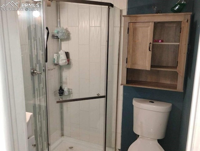 bathroom with toilet and a shower with shower door