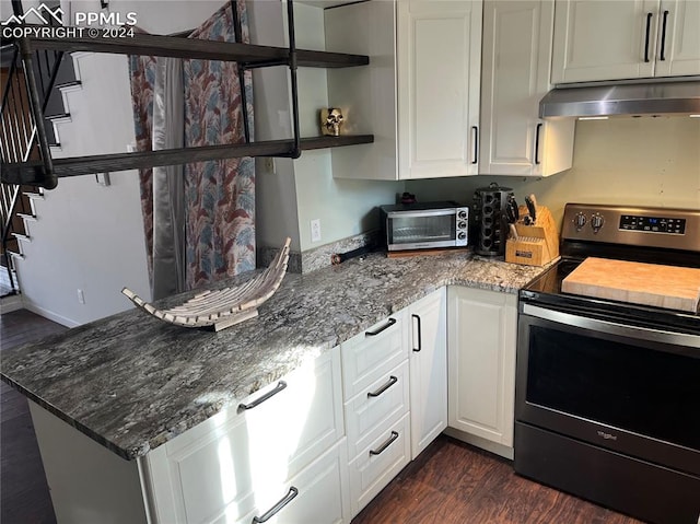 kitchen with dark stone counters, electric stove, white cabinets, and dark wood-type flooring