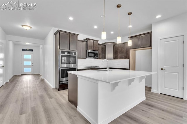 5265 Gansevoort Dr, Colorado Springs, CO 80927 - kitchen with stainless steel appliances, dark brown cabinets, light wood-style flooring, and recessed lighting