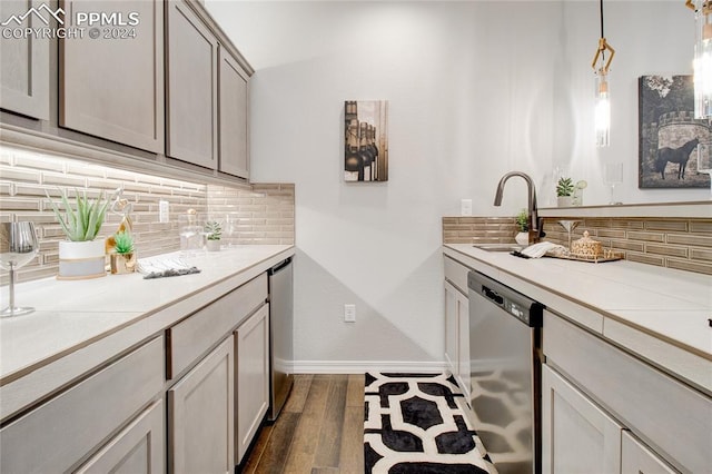 bar featuring decorative backsplash, dark wood-type flooring, sink, decorative light fixtures, and dishwasher