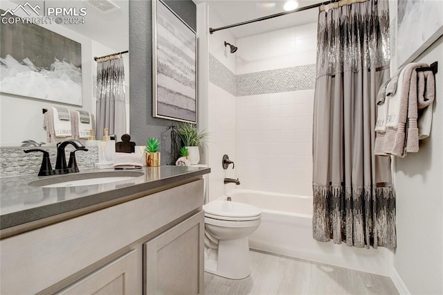 full bathroom featuring vanity, toilet, wood-type flooring, and shower / tub combo