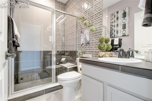 bathroom featuring vanity, tile patterned flooring, toilet, walk in shower, and tile walls