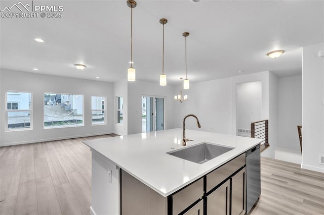 5265 Gansevoort Dr, Colorado Springs, CO 80927 - kitchen with stainless steel dishwasher, light wood finished floors, open floor plan, light countertops, and pendant lighting
