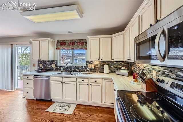 kitchen with white cabinetry, sink, dark wood-type flooring, tasteful backsplash, and appliances with stainless steel finishes