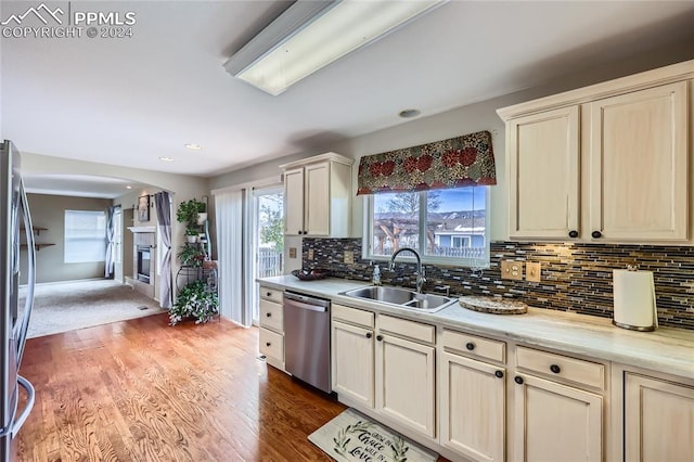 kitchen featuring cream cabinets, sink, decorative backsplash, appliances with stainless steel finishes, and wood-type flooring