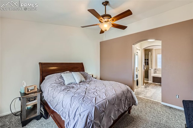 carpeted bedroom with ceiling fan and ensuite bathroom