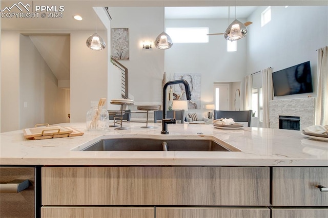 kitchen featuring a fireplace, decorative light fixtures, and a wealth of natural light