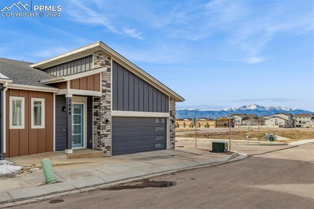 7680 Almond Wood Loop, Colorado Springs, CO 80908 - view of front of home with a mountain view, board and batten siding, stone siding, and an attached garage