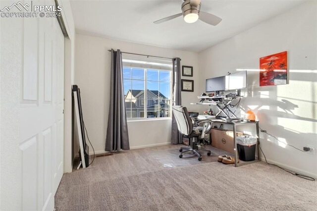 carpeted home office featuring ceiling fan