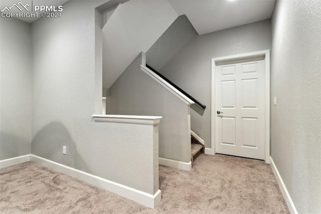 staircase with carpet floors and vaulted ceiling