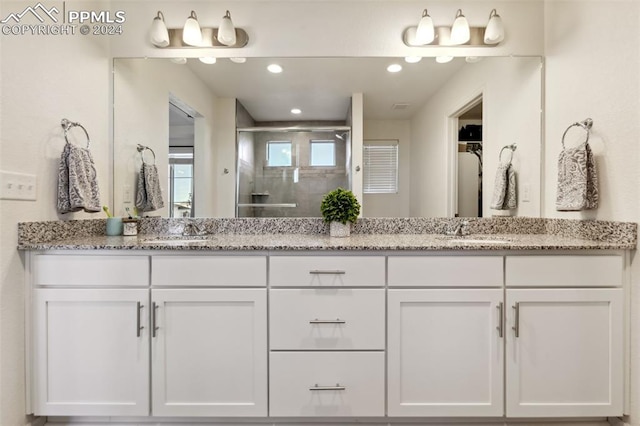 bathroom with vanity and a shower with shower door