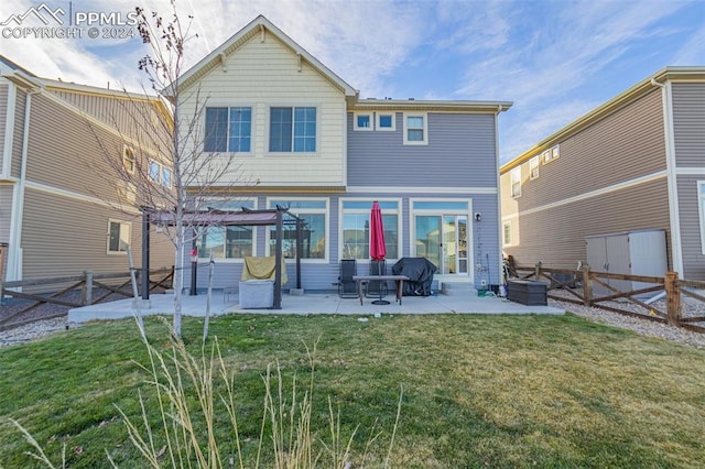 rear view of property featuring a yard and a patio area