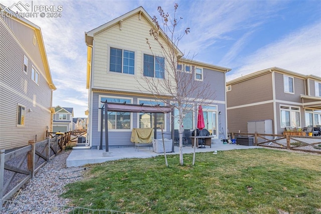 back of house with a yard and a patio