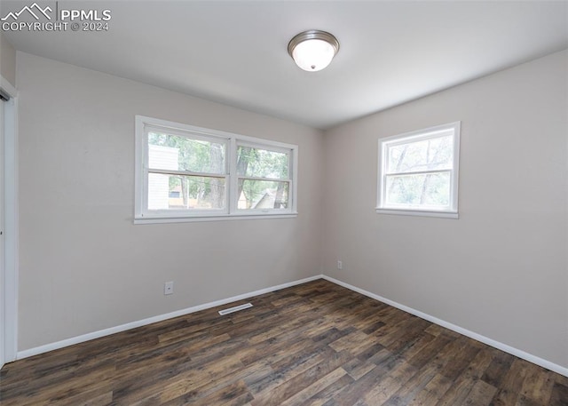 unfurnished room with plenty of natural light and dark hardwood / wood-style flooring